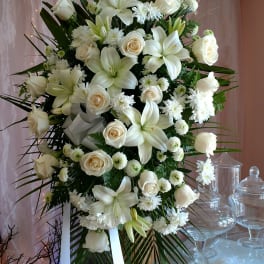 Large white floral standing spray on an easel with ribbon