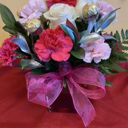 Bouquet of pink and white carnations with chocolate truffles and a pink ribbon