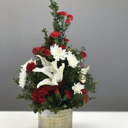 Red and white floral arrangement in a gold-toned container