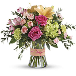 Pink and peach mixed bouquet with roses, lilies, and green hydrangea in a clear glass vase