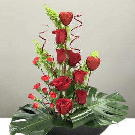 Red roses and carnations in a black bowl with heart picks