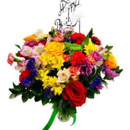 Colorful mixed bouquet with roses and daisies in a glass vase