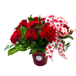 Red roses and carnations in a vase with a heart-patterned ribbon