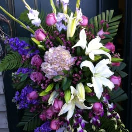 Large standing spray with white lilies, pink roses, and purple flowers