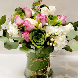 Pink and white roses with hydrangeas in a glass vase