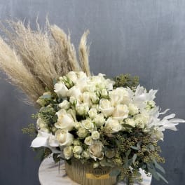 White rose arrangement in a round box with pampas grass