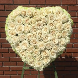 Heart-shaped arrangement of white roses on an easel