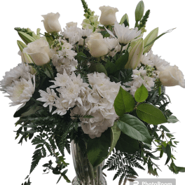 White roses and chrysanthemums in a clear glass vase
