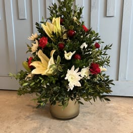 Mixed floral arrangement in a gold vase with lilies, chrysanthemums, and red accents