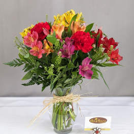 Mixed bouquet of colorful flowers in a clear glass vase