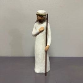 Small figurine of a man in a white robe holding a staff