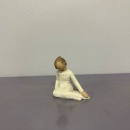 Small figurine of a seated person in a white outfit