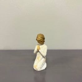 Small angel figurine in a white robe standing on a table