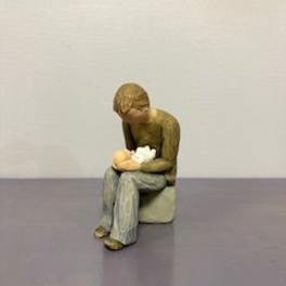 Small figurine of a seated person holding a baby