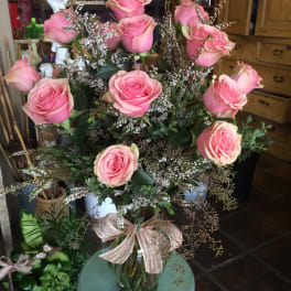 Pink roses in a clear glass vase with airy filler flowers