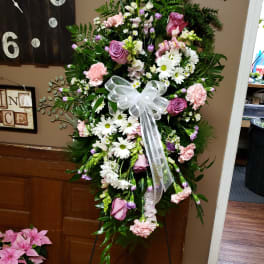 Standing floral spray with pink and white flowers and a white ribbon bow