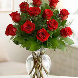 Red roses arranged in a clear glass vase