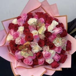 Bouquet of red, pink, and white roses wrapped in pink paper