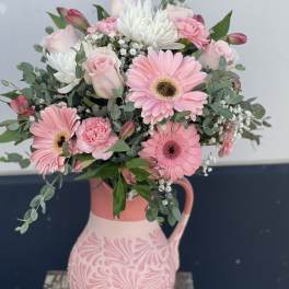 Pink and white bouquet in a decorative ceramic pitcher