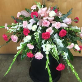 Large pink and white floral arrangement in a black container