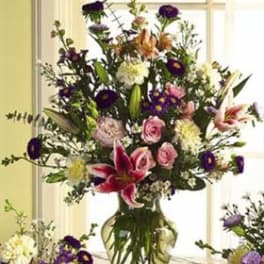 Tall mixed bouquet in a glass vase with pink roses and lilies