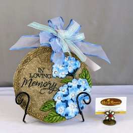 Decorative memorial plaque with blue flowers and ribbon bow