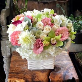 Bouquet of pink, white, and green flowers in a white vase