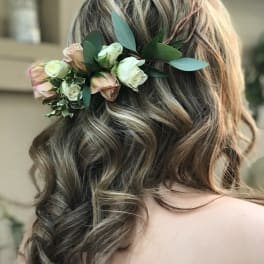 Floral hairpiece with blush and white roses in a woman's hair
