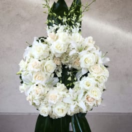 White rose and lily wreath with dark green leaves