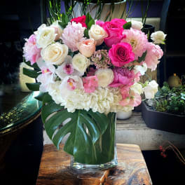 Pink and white floral arrangement in a clear glass vase