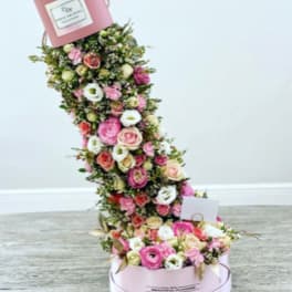 Tall pink floral arrangement in a round box with a matching top box