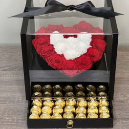 Black display box with a heart of red and white roses above a drawer of gold-wrapped chocolates