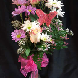 Pink and white mixed bouquet in a glass vase with a pink ribbon