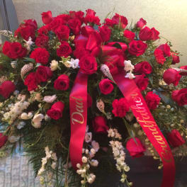 Large red rose funeral spray with red ribbons and white accents