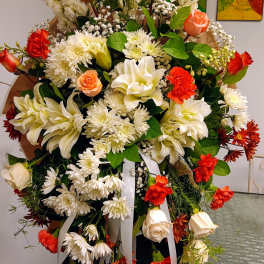Large standing floral spray with white lilies, roses, and red carnations