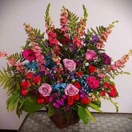 Large mixed bouquet with roses, gerbera daisies, and snapdragons in a basket
