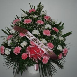 Pink and white carnation funeral spray with a memorial ribbon