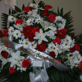 Large red and white funeral spray with a memorial ribbon