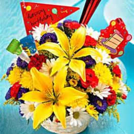 Bright mixed bouquet with yellow lilies and colorful flowers in a basket