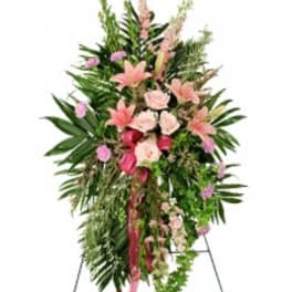Standing floral spray with pink lilies and roses on a metal easel