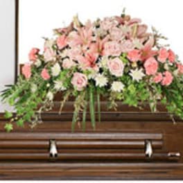 Pink and white floral arrangement on a casket