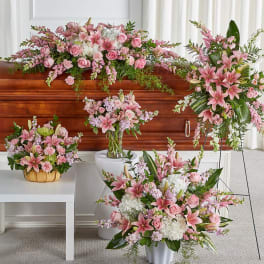 Pink and white funeral flowers arranged around a casket
