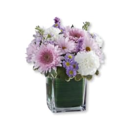 Pink and white flowers arranged in a square glass vase