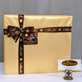 Large gold gift box with brown ribbon and a small card holder in front