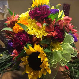 Bright mixed bouquet with sunflowers, carnations, and purple flowers