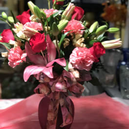 Bouquet of red roses, pink lilies, and carnations in a vase