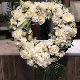 Heart-shaped white floral wreath with roses and daisies