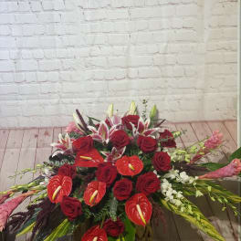 Large red floral arrangement with roses, lilies, and anthuriums
