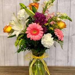 Mixed bouquet in a glass vase with a yellow ribbon