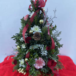 Christmas tree-shaped floral arrangement with red ribbon and ornaments